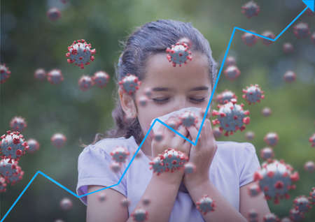 Composition of covid 19 cells and blue line ascending over sick girl blowing her nose. global coronavirus pandemic and health concept digitally generated image.の写真素材