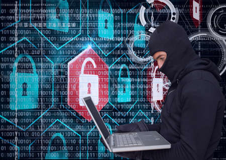 Composition of binary coding and online security padlocks over hacker in hood using laptop. online...