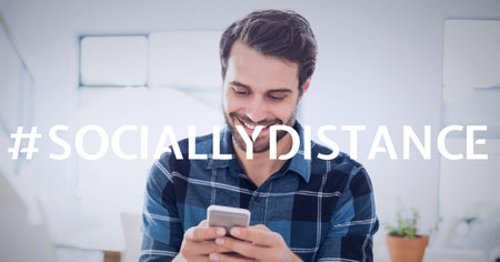 Socially distance text over smiling man using smartphone. covid 19 pandemic and social distancing...
