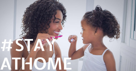 Stay home text over smiling senior mother with daughter brushing teeth. covid 19 pandemic and social distancing concept digitally generated image.の写真素材