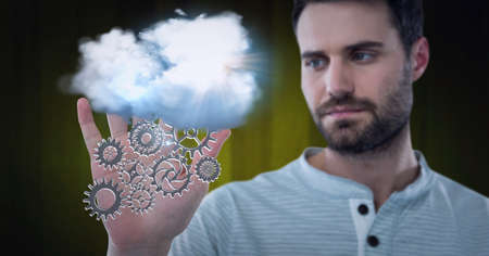 Composition of network of digital cogs with white cloud over hand of man. global technology and...