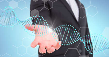 Dna structure and chemical structures over mid section of business man with cupped hand. global business and medical research technology conceptの写真素材