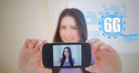 Composition of 6g text and data processing over woman holding smartphone with picture of herself....