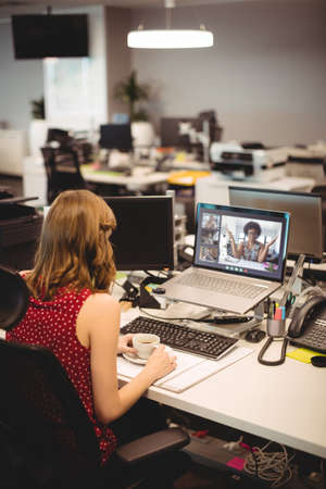Caucasian woman having video call with coworkers. online meeting, working in isolation during quarantine lockdown.の写真素材