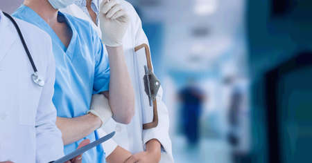 Mid section of team of medical professionals and health workers against hospital in background. healthcare and medical professionalism conceptの写真素材