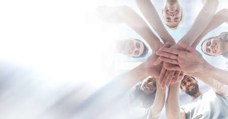 Composition of light background over group of young businesspeople teaming up. global business,...