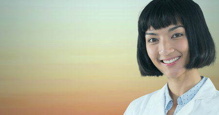 Portrait of asian female doctor smiling against brown gradient blue background. healthcare and medical research technology conceptの写真素材