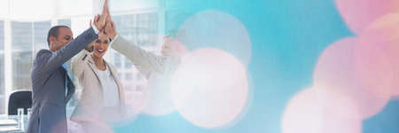 Composition of business people high fiving with spots of light. business, motivation and teamwork concept digitally generated image.の写真素材