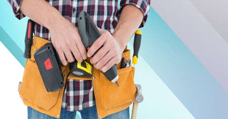 Midsection of handy man holding drill on blue and white stripes. diy and home decoration concept digitally generated image.の写真素材