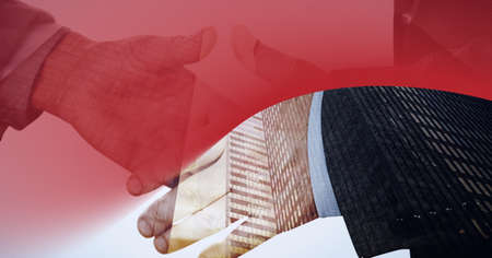 Red technology background over mid section of two businessmen shaking hands against tall buildings....