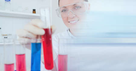 Composition of female scientist in lab holding test tube with motion blur. science and research technology concept digitally generated image.の写真素材