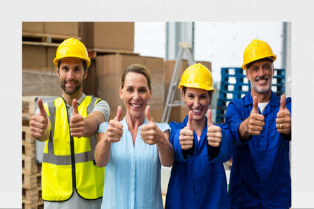 Composition of smiling male and female warehouse workers with thumbs up. teamwork, professionals and success concept digitally generated image.の写真素材