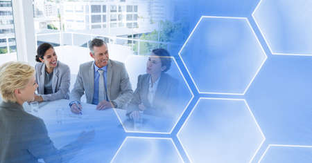 Composition of smiling male and female business colleagues with blue hexagon overlay. global...
