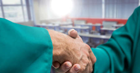 Composition of male doctors shaking hands over empty room in background. medicine, deal and agreement concept digitally generated image.の写真素材