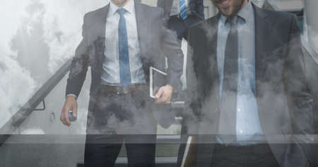 Composition of businessmen walking down steps in modern building. global business travel and finance...