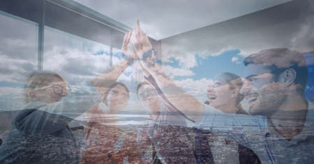 Composition of group of friends high fiving over summer landscape background. teamwork and success concept digitally generated image.の写真素材