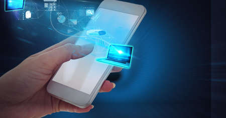 Digital interface with data processing over laptop against hand using smartphone. computer interface...