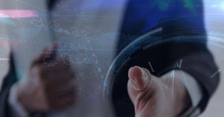 Stock market data processing against mid section of businessman approaching for a hand shake. global finance and business technology conceptの写真素材