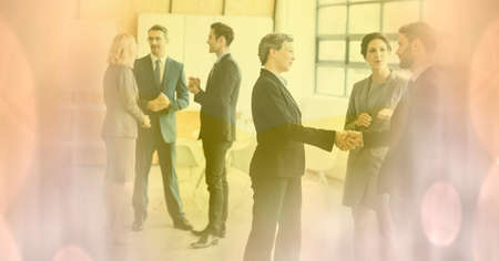 Composition of businessman handshake in meeting with glowing pink spots of light. business and success concept digitally generated image.の写真素材