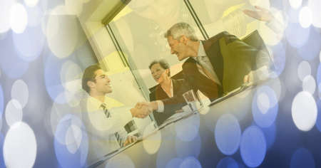 Composition of businessman handshake with glowing blue spots of light. business and success concept...