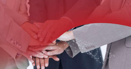 Network of connections over mid section of businesspeople stacking their hands together. global...
