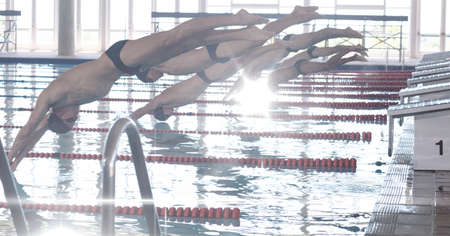 Composition of men jumping into swimming pool. sport, fitness and active lifestyle concept digitally generated image.の写真素材