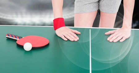 Composition of mid section of female table tennis player leaning on table with ball and racket. sport, fitness and active lifestyle concept digitally generated image.の写真素材