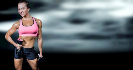 Composition of smiling strong caucasian woman lifting dumbbells with copy space. sport, fitness and active lifestyle concept digitally generated image.の写真素材