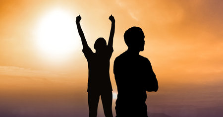 Composition of fit male and female silhouettes raising hands over light blur. sport, fitness and active lifestyle concept digitally generated image.の写真素材