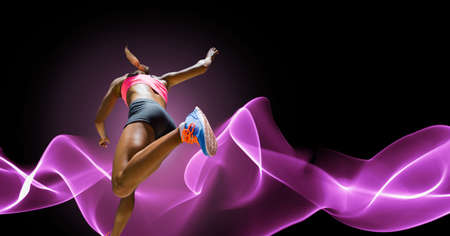 Composition of athletic woman running on black background. sport, fitness and active lifestyle concept digitally generated image.の写真素材