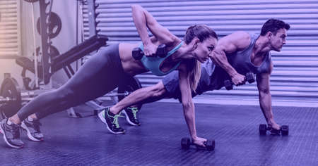 Composition of fit man and woman exercising with dumbbells over light blur. sport, fitness and...