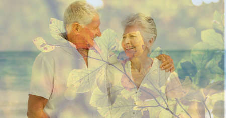 Composition of senior couple embracing on beach and autumn foliage. healthy active retirement...