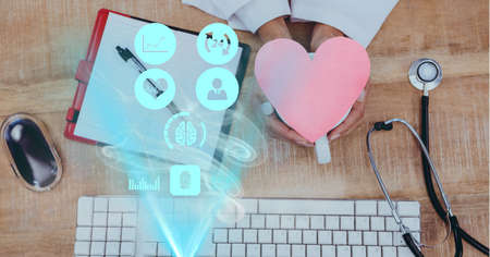 Composition of screen with medical data processing and heart over female doctor's desk. global...