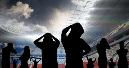Composition of silhouettes of disappointed sports fans on sports stadium. sport and competition concept digitally generated image.の写真素材