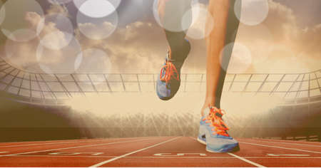 Composition of legs of running athlete on racing track with spots of light. sport and competition concept digitally generated image.の写真素材