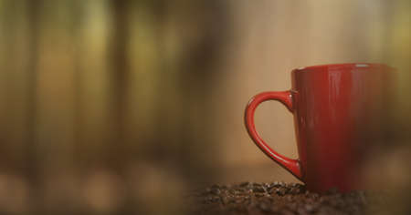 Composition of red cup of coffee with coffee beans over wooden surface with copy space. drink and...