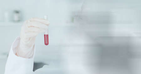 Composition of scientist holding test tube with red liquid working in laboratory and copy space....