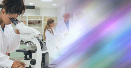 Composition of male and female lab technicians at work, with colourful blurred copy space to right....