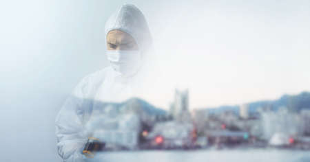 Composition of person wearing ppe suit and mask, with blurred city and copy space. medical services...