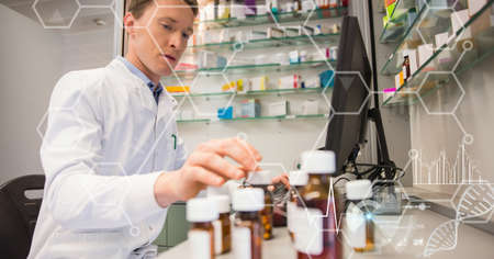 Composition of male pharmacist at work, with medical research data interface screen. global medicine, research and digital interface concept digitally generated image.の写真素材