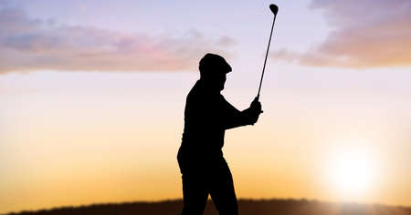 Composition of silhouette of male golf player over landscape and sun setting with copy space. sport and competition concept digitally generated image.の写真素材