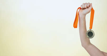 Composition of caucasian female athlete holding gold medal with copy space on yellow background. sport, winning and competition concept digitally generated image.の写真素材