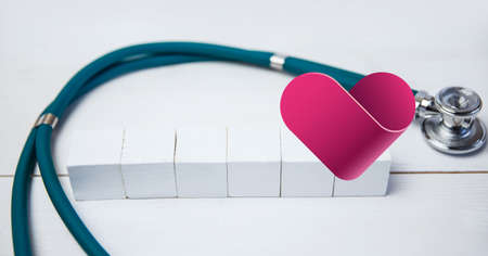 Composition of heart and stethoscope over cubes with copy space. medicine and healthcare concept...