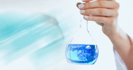 Composition of hand of lab technician holding flask of blue liquid, with blue blurred copy space....