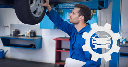Composition of car and cog icon over caucasian car mechanic checking car tyre. independent business,...