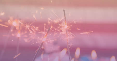 Composition of sparklers with copy space over american flag. patriotism and celebration concept...