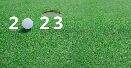 Composition of 2023 number with golf ball by hole on golf course. sports calendar and competition concept digitally generated image.の写真素材