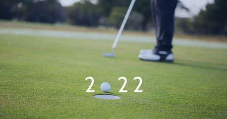 Composition of 2022 number with golf ball by hole on golf course. sports calendar and competition concept digitally generated image.の写真素材