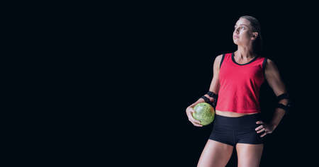 Composition of caucasian female handball player holding ball with copy space on black background....