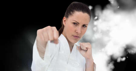 Compostion of caucasian female karate fighter on black background with white blur. championships,...